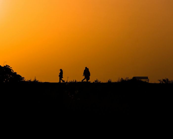 Person stretching peacefully during sunrise with a warm glow.